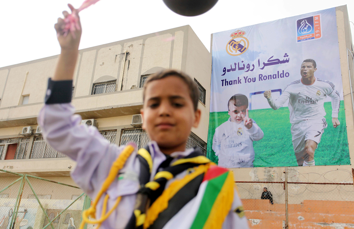 Palestinian chlidren hold ballons and posters bearing a portrait of Palestinian boy Ahmed Dawabsha, 5, who suffered severe burns in an arson attack by suspected Jewish attackers on his family home last July and in which his younger brother, Ali, and his p